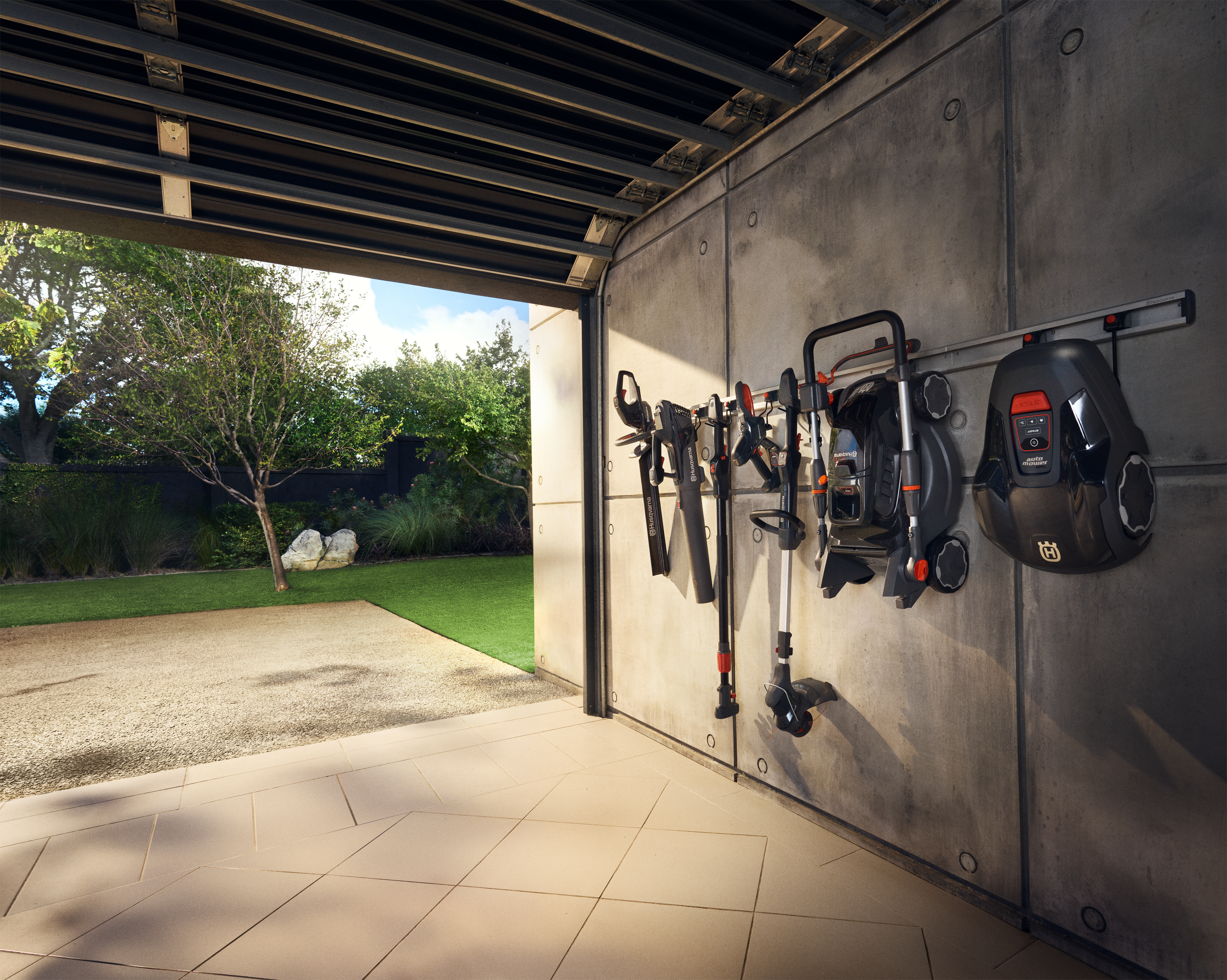 Husqvarna Aspire batteriverktyg på en förvaringsskena.